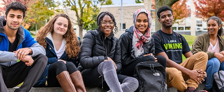 Photo of students sitting and smiling.