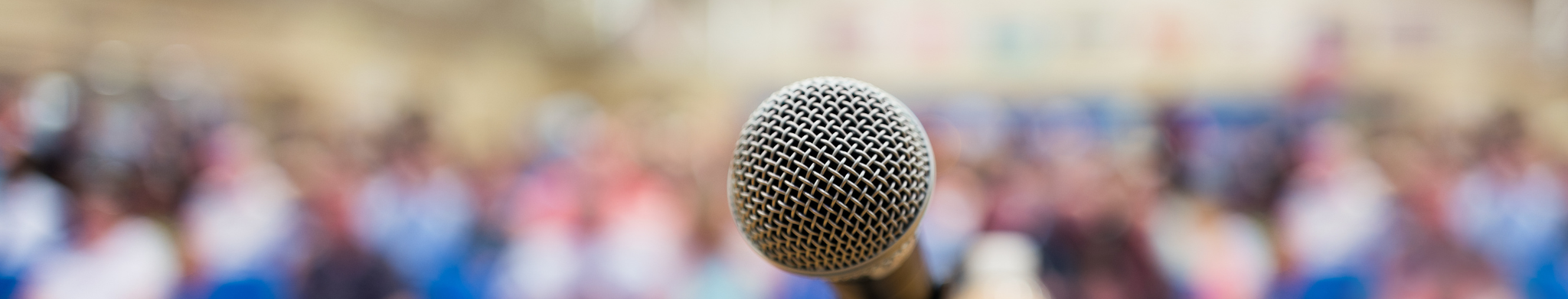Photo of a microphone stand, for the point of view of looking out at a crowd.