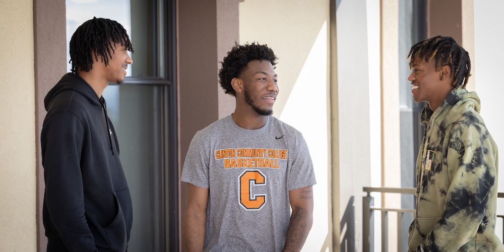 Photo of three students talking and smiling.